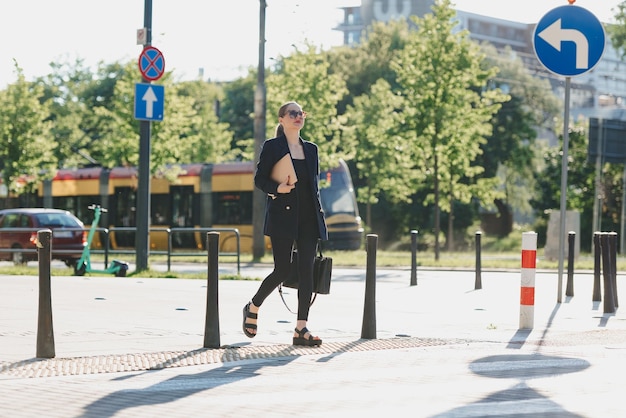 Une agente immobilière en blazer tient un ordinateur portable dans le quartier financier