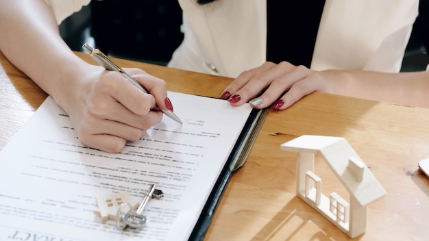 Les agents immobiliers et le client acceptent d'acheter une maison et signent des documents contractuels avec le client.