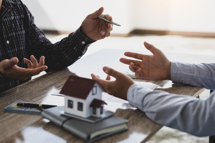Photo les agents immobiliers discutent avec les clients de l'achat de maisons et de terrains après avoir conclu un contrat d'achat de maison et de prêt.