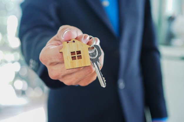 Les agents de vente de maisons remettent les clés de la maison aux nouveaux propriétaires