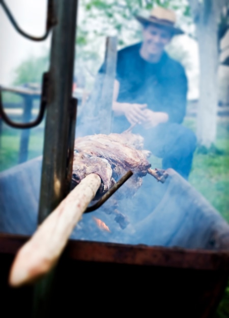 Agneau en feu et homme souriant tenant