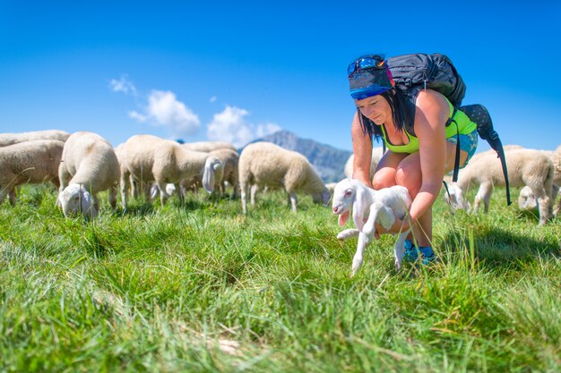 Un agneau nouveau-né offert au troupeau par une femme sportive