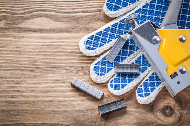 Photo agrafeuse de construction gants de sécurité agrafes sur planche de bois