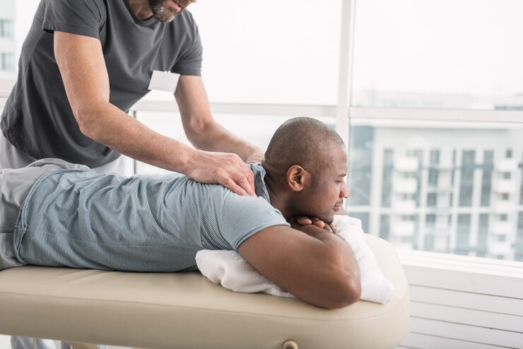 Agréable détente. Agréable bel homme appréciant le massage tout en visitant le centre médical