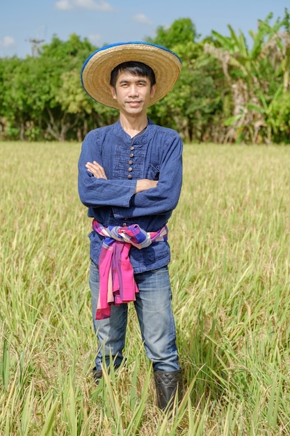 Agriculteur asiatique portant une robe bleue traditionnelle debout avec les bras croisés à la ferme