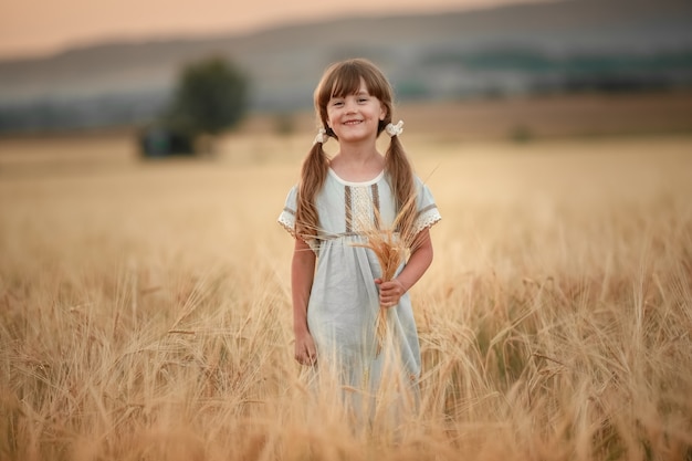 Agriculteur bébé fille dans le champ de blé doré naturel