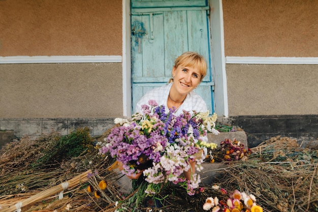 agriculteur dans le pays avec un bouquet de fleurs séchées dans ses mains posant pour la caméra