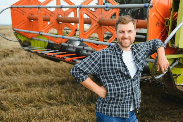 Agriculteur debout dans un champ de blé à la récolte