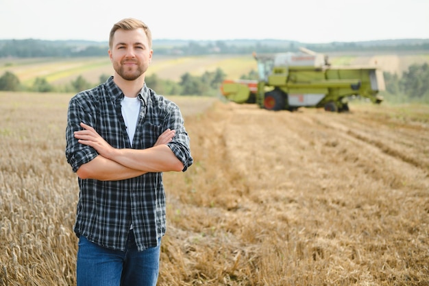 Agriculteur debout dans un champ de blé à la récolte