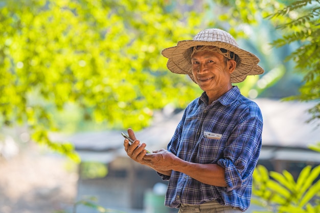 Agriculteur homme asiatique avec un smartphone