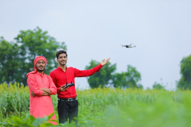 Agriculteur indien et agronome à l'aide de drone au champ agricole