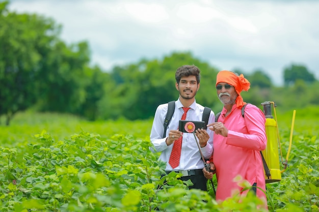 Un agriculteur indien discute avec un agronome à la ferme et collecte des informations