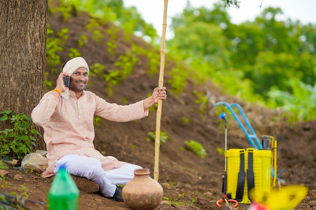 Agriculteur indien parlant au téléphone portable au domaine de l'agriculture