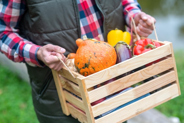Un agriculteur portant une boîte avec des légumes