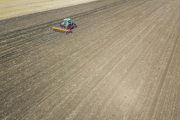 Agriculteur semant des cultures sur le terrain. Vue aérienne de l'ensemencement.