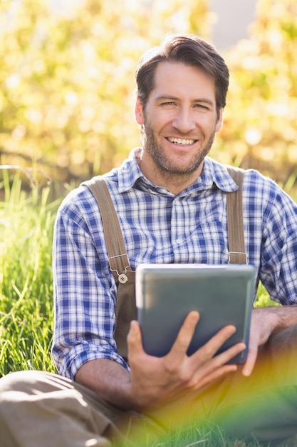 Agriculteur souriant à l&#39;aide d&#39;une tablette numérique