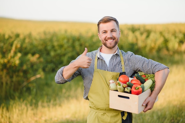 Agriculteur tenant une boîte avec des légumes biologiques