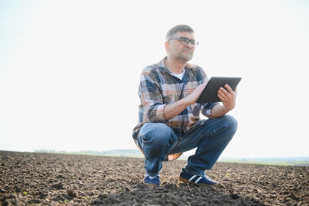 Un agriculteur vérifie la qualité du sol avant de semer