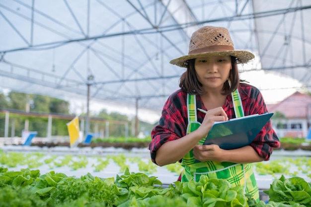 Agricultrice asiatique travaillant à la ferme de saladePlanter des légumes hydroponiques biologiques pour les petites entreprises