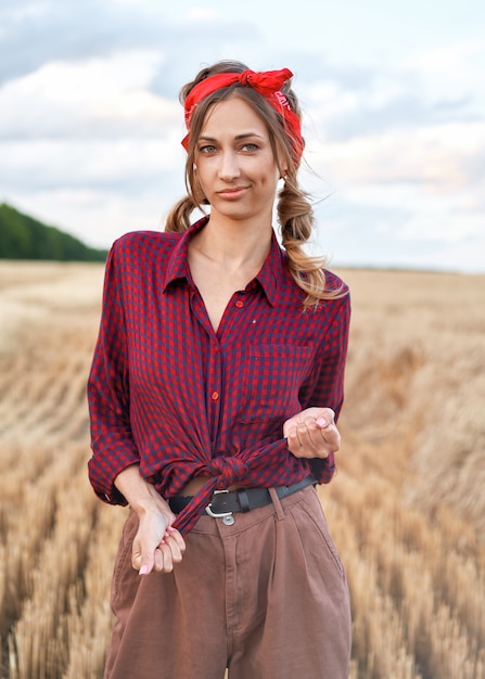 Agricultrice debout sur un champ de blé