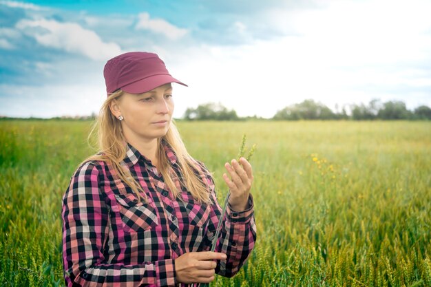Une agricultrice examine des épis de blé dans le champ