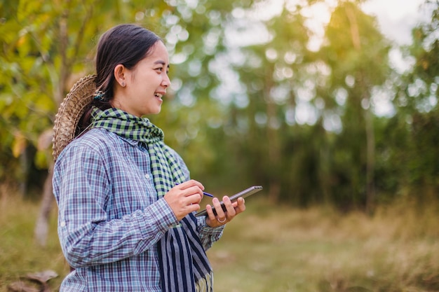 agricultrice utilisant la technologie mobile dans une rizière