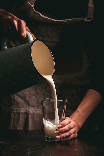 Agricultrice avec un verre de lait. problèmes de concept dans le secteur agricole.