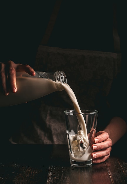 Agricultrice avec un verre de lait. problèmes de concept dans le secteur agricole.