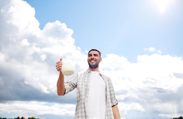 l'agriculture, l'élevage, les gens et le concept laitier - l'homme ou l'agriculteur avec une cruche de lait à la campagne