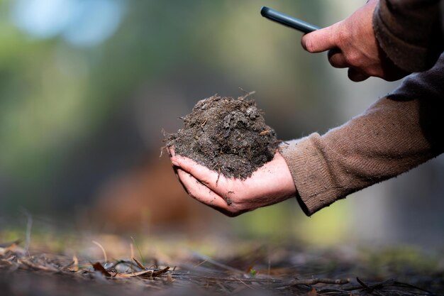 Photo agronomiste dans une ferme pratiquant l'agronomie tenant le sol faisant des tests de sol dans son laboratoire à la maison regardant la vie et la santé du sol et le compost dans les doigts