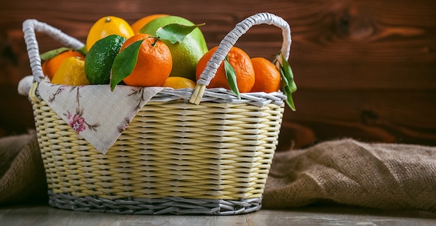 Agrumes dans un panier en osier sur un fond en bois