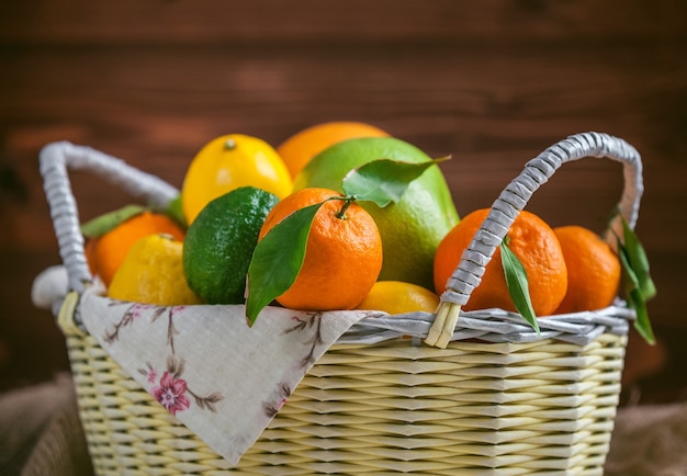 Agrumes dans un panier en osier sur un fond en bois