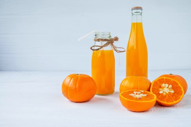 Agrumes frais et bouteilles de jus d'orange pressé