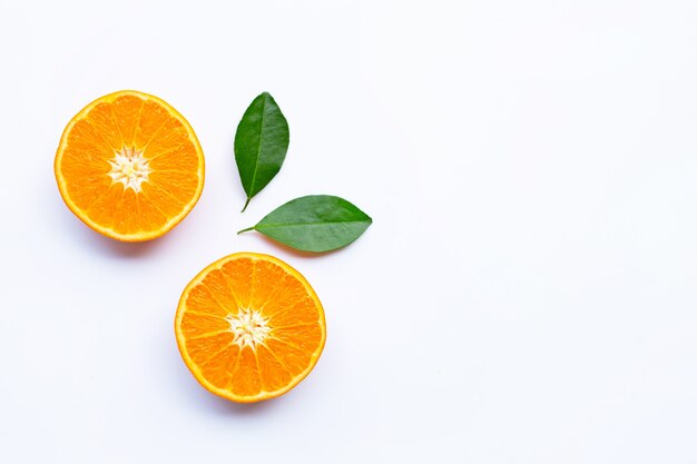 Agrumes orange frais avec des feuilles sur fond blanc.