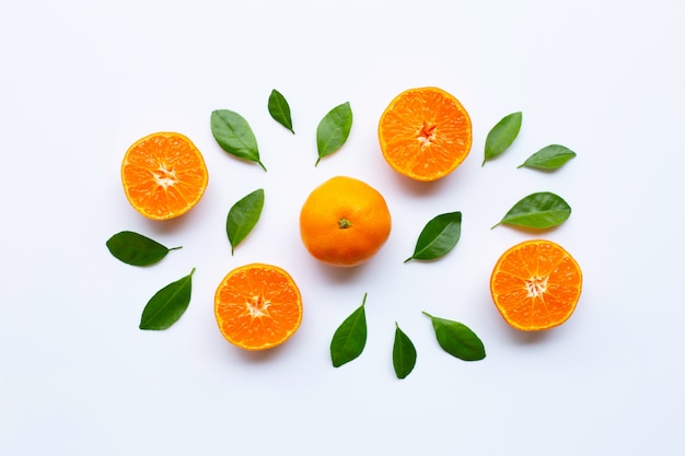 Agrumes orange frais avec des feuilles vertes sur blanc.