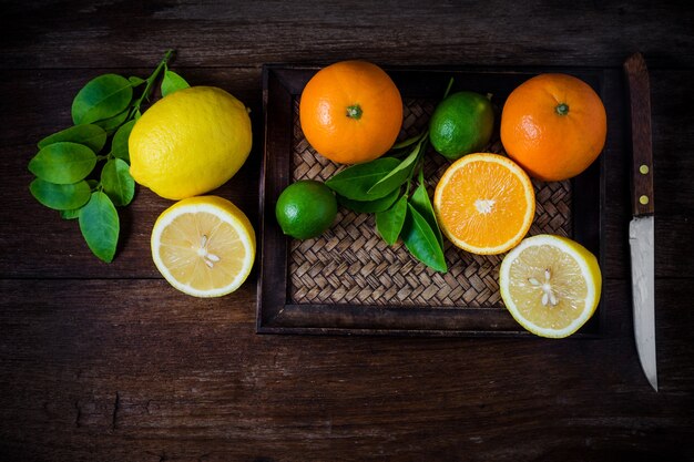 Les agrumes. Oranges, limes et citrons. Vue de dessus sur fond de table en bois