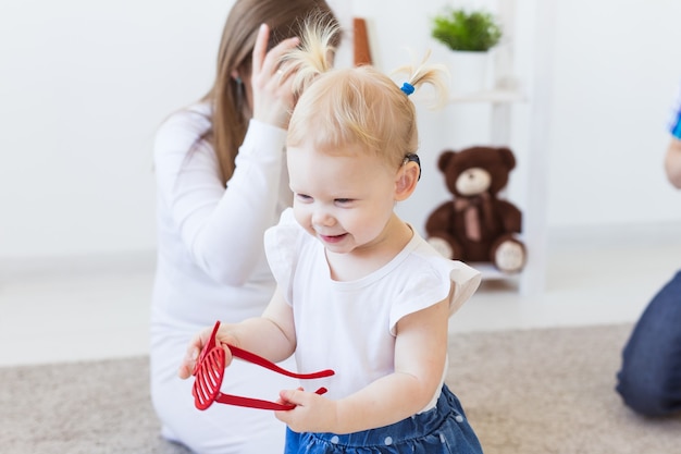 Aide auditive dans l'oreille de la petite fille. Enfant en bas âge portant un appareil auditif à la maison. Enfant handicapé