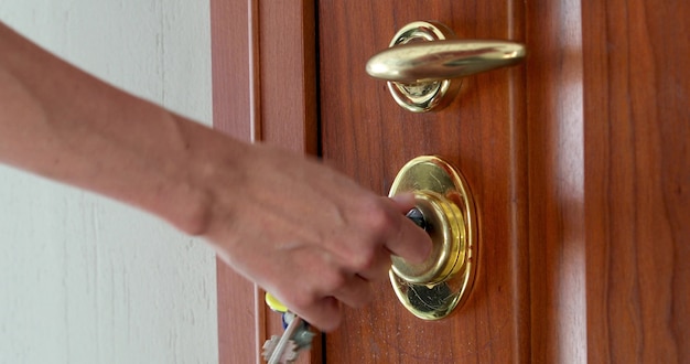 À l'aide d'une clé pour ouvrir la serrure de la porte d'entrée