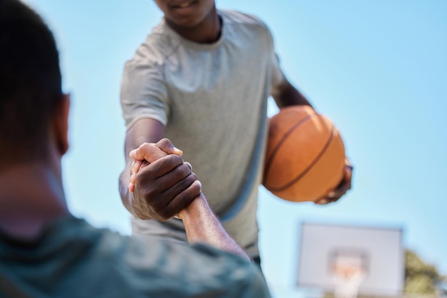 Aide et équipe de basket-ball sur un terrain jouant un match d'entraînement ou s'entraînant ensemble pour une compétition Sports de fitness et homme aidant son ami sur un terrain de basket-ball pendant un match ou un entraînement