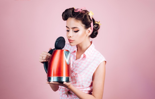 Aide ménagère jolie fille dans un style vintage pin up femme avec maquillage à la mode pin-up fille avec des cheveux de mode femme au foyer parfaite femme rétro cuisiner dans la cuisine