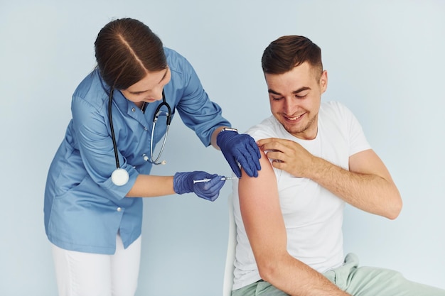 À l'aide d'une seringue Médecin en uniforme faisant la vaccination au patient
