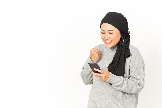 À l'aide de Smartphone de belle femme asiatique portant le hijab isolé sur fond blanc