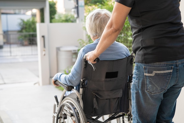 Aide et soins aux soignants Asiatique senior ou âgée vieille dame patiente assise sur un fauteuil roulant à l'hôpital de soins infirmiers sain concept médical fort