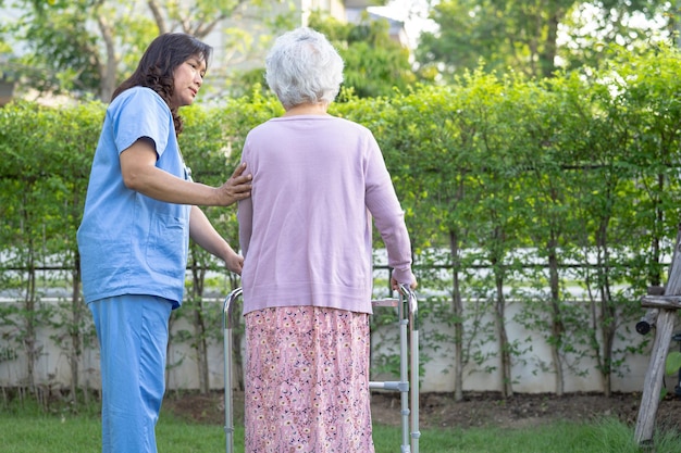Aide et soins du médecin Une vieille dame asiatique âgée ou âgée utilise une marchette avec une bonne santé tout en marchant au parc pendant de bonnes vacances fraîches
