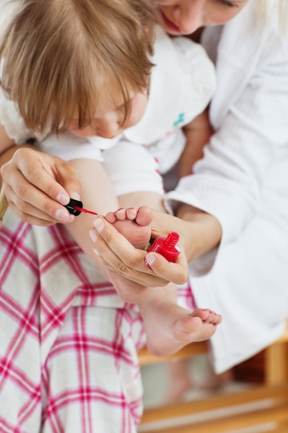 Photo aider la mère à faire les ongles de sa fille