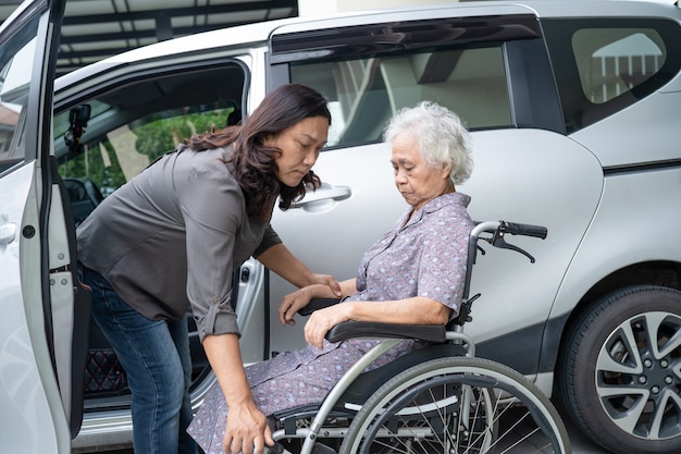 Aidez et soutenez la patiente asiatique âgée ou âgée qui se prépare à se rendre à sa voiture.