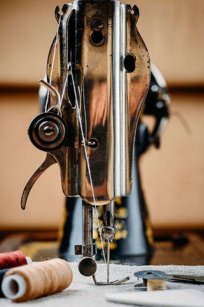 Aiguille en acier avec boucleur et un pied-de-biche de la vieille machine à coudre vintage main close-up