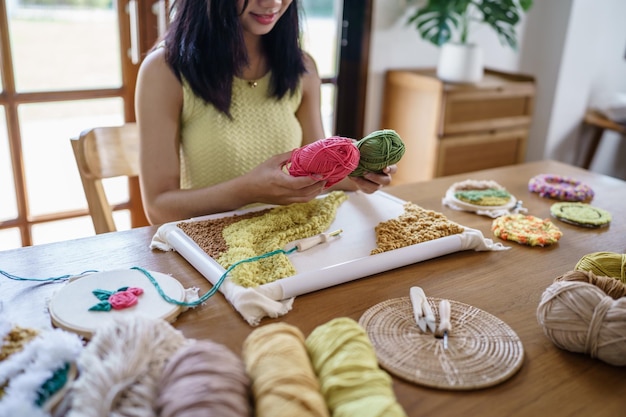 Aiguille de poinçon femme asiatique faisant du tricot passe-temps fait à la main dans un atelier de concepteur de travail de concepteur de projet d'artisanat fait à la main concept de broderie bricolage