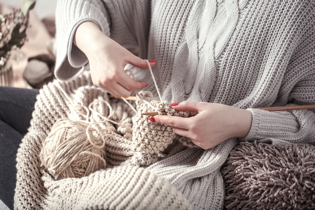 Aiguilles à tricoter en bois vintage et fil dans les mains de la femme