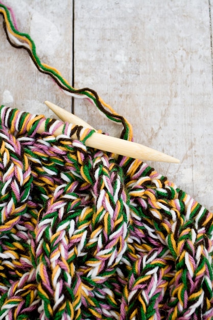 Aiguilles à tricoter et fil sur fond de bois fond de tricot de laine naturelle